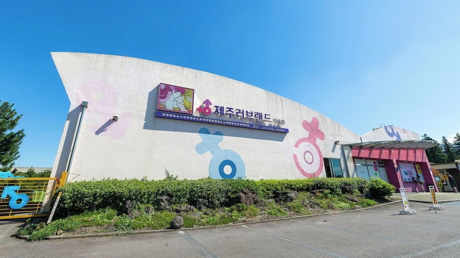 濟州 Love Land 白色弧形館舍外牆、韓文 제주러브랜드 招牌與粉藍色標誌