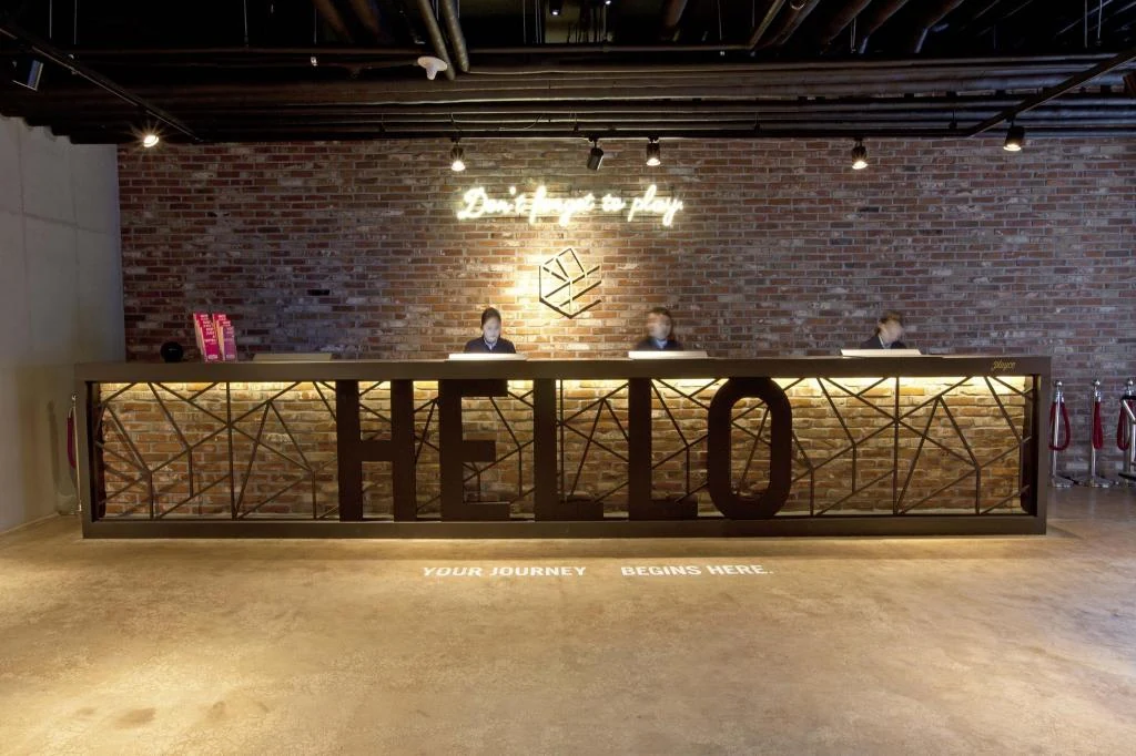 Playce Camp Jeju 真實 HELLO 接待大堂與磚牆櫃台