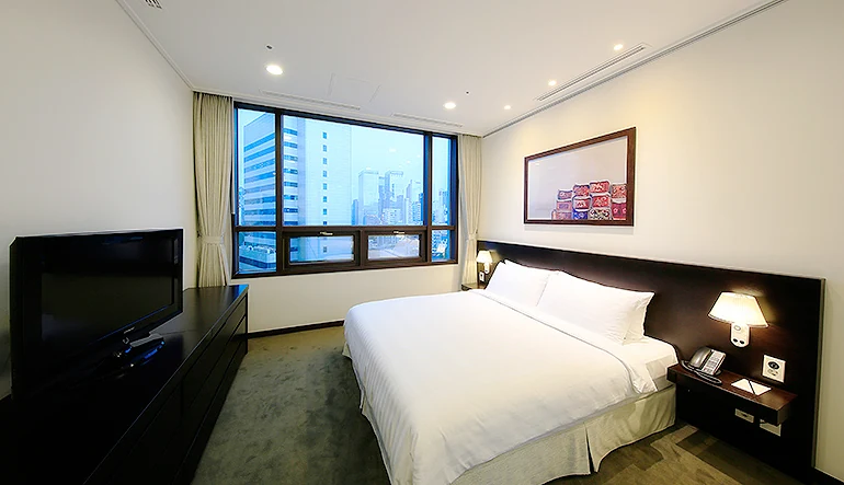 Orakai Insadong Suites 三房公寓其中一間雙人臥室，展示三代家庭可關門休息的獨立睡眠區