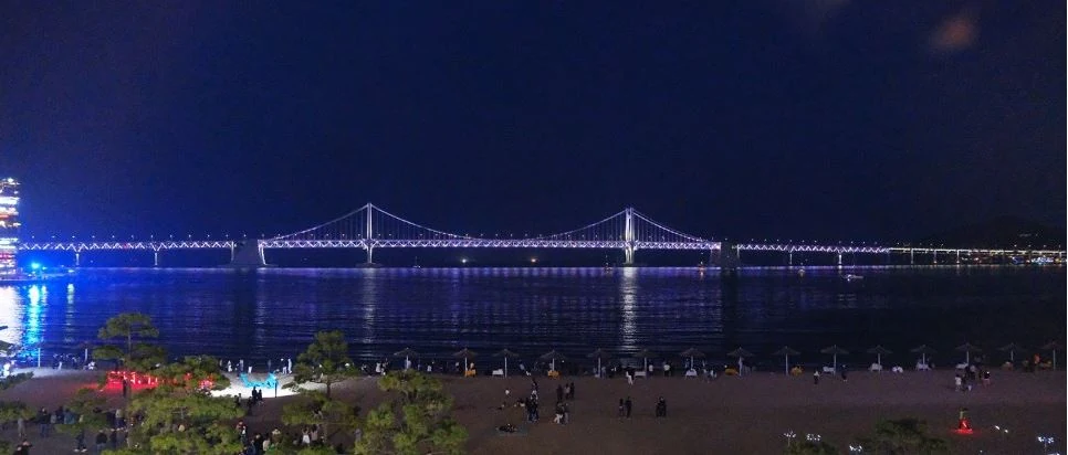 廣安里海灘上空的無人機燈光秀實景，海面前方可見發光圖案